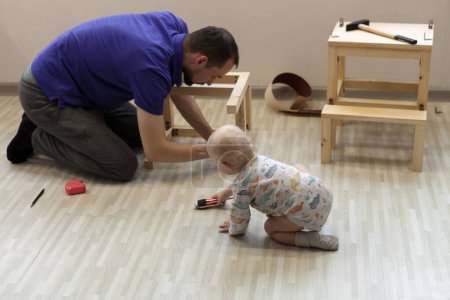 Téléchargez les photos : Père faisant poste d'aide en bois pour son fils avec son aide - en image libre de droit