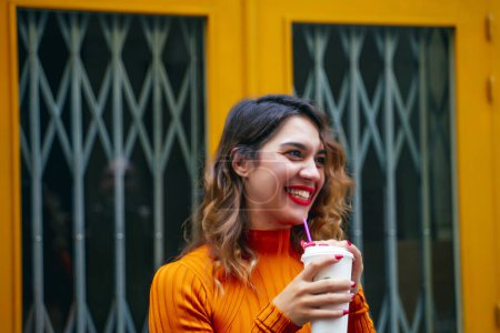 Photo for Attractive young woman drinking coffee in the street - Royalty Free Image