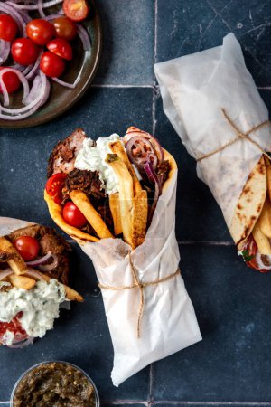 Foto de Comida griega para llevar con papas fritas y cebollas - Imagen libre de derechos