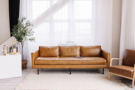Foto de Luminoso y moderno salón con sofá de cuero y grandes ventanales - Imagen libre de derechos