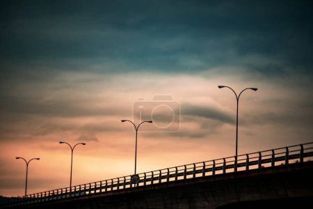Téléchargez les photos : Golden Gateway : Pont sous le ciel nuageux du coucher du soleil - en image libre de droit