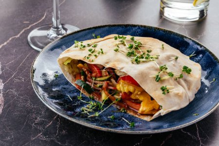 Photo for Turkish pita with meat, vegetables and sauce on a plate - Royalty Free Image