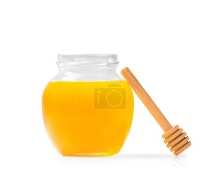 Foto de Fresh honey in a jar with a wooden dipper on a white isolated background.Honey in an open glass jar with a honey stick. Honey in a jar on a white background. - Imagen libre de derechos