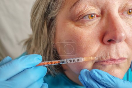 Foto de La mujer mayor se inyecta en los labios. Mujer en salón de belleza - Imagen libre de derechos