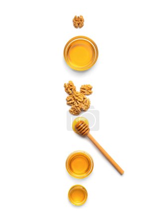 Téléchargez les photos : Miel en pots, trempette et noix sur fond blanc vue du dessus. - en image libre de droit