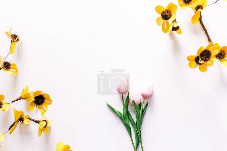 Photo for Spring flowers and pink tulips laying flat on white surface - Royalty Free Image
