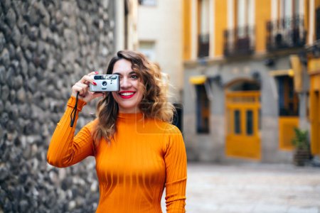 Photo for Attractive young woman making photos in the street - Royalty Free Image