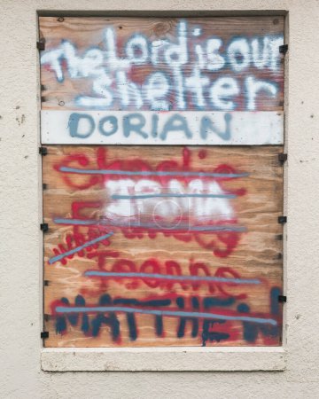 Boarded window for hurricane with names of past hurricanes painted