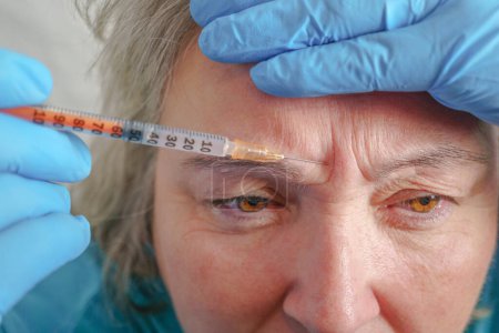 Téléchargez les photos : Femme âgée ayant une procédure d'injection de botox. Traitement cosmétique - en image libre de droit