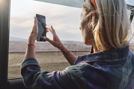 Téléchargez les photos : Femme prenant une photo du Grand Canyon par la fenêtre de la voiture - en image libre de droit