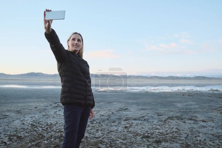 Téléchargez les photos : Une femme prend un selfie sur fond de montagnes et de lacs - en image libre de droit