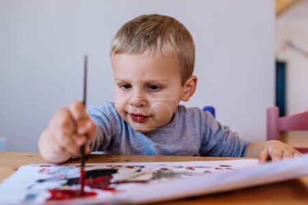 Foto de Enfocado niño niño pintura dentro - Imagen libre de derechos