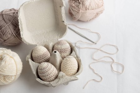 Photo for Set of cute easter crocheted eggs, pastel color, striped pattern in the eggbox with a yarn. Horizontal - Royalty Free Image