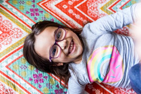 Photo for Happy young girl laying on blanket smiling - Royalty Free Image