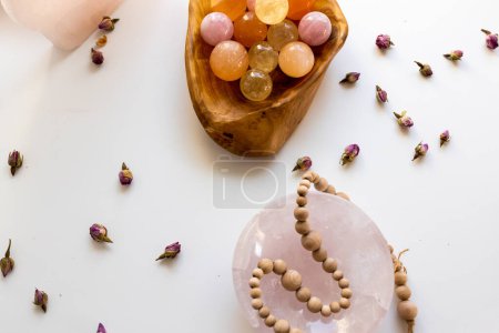 Foto de Cuenco de madera de bolas de cristal de colores con rosas secas - Imagen libre de derechos