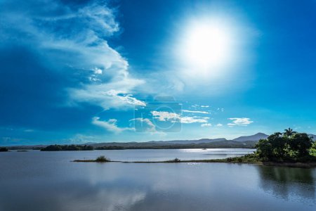 Téléchargez les photos : Coucher de soleil paysage d'un lac avec des élévations en arrière-plan - en image libre de droit