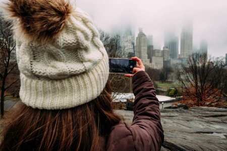 Téléchargez les photos : Jeune femme prenant une photo de NYC skyline au téléphone - en image libre de droit