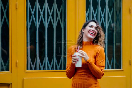 Photo for Attractive young woman drinking coffee in the street - Royalty Free Image