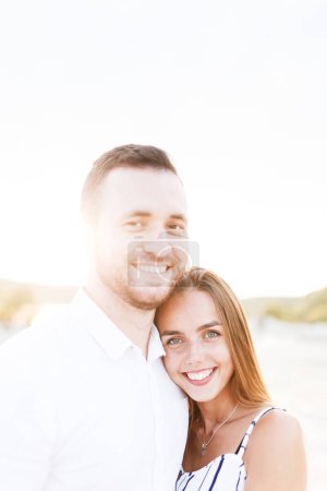 Téléchargez les photos : Man and a woman are hugging on a sandy beach in summer - en image libre de droit
