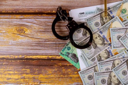 Photo for Tax form financial with handcuffs and currency US dollar banknotes - Royalty Free Image