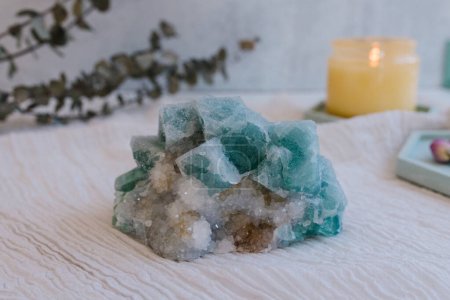 Blue and white sparkly quartz with yellow candle and eucalyptus