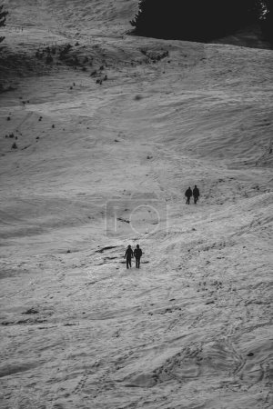Téléchargez les photos : Photo en noir et blanc de personnes marchant dans les montagnes suisses d'hiver - en image libre de droit