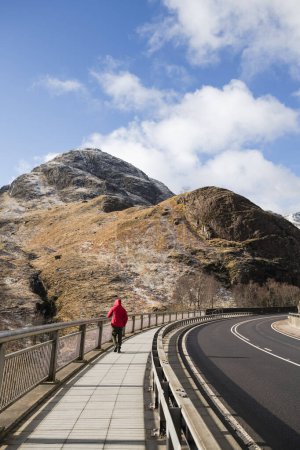 Téléchargez les photos : Solo marchant sur le trottoir dans les hauts plateaux écossais - en image libre de droit