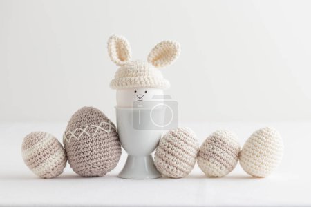 Téléchargez les photos : Œuf de Pâques au crochet chapeau avec des oreilles de lapin sur fond blanc. Bannière horizontale, carte postale avec espace de copie - en image libre de droit