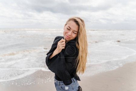 Photo for Dreamy young blonde woman with long wavy hair on the beach - Royalty Free Image