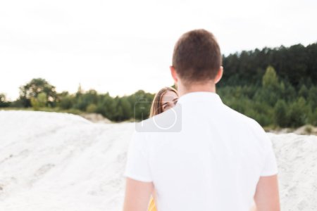 Téléchargez les photos : Couple amoureux regardent dans les yeux de l'autre dans la plage de sable fin - en image libre de droit