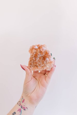 Photo for Hand holding up orange and white calcite from Hubei China - Royalty Free Image