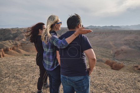 Téléchargez les photos : Trois personnes regardant le Grand Canyon d'un point de vue, venteux - en image libre de droit