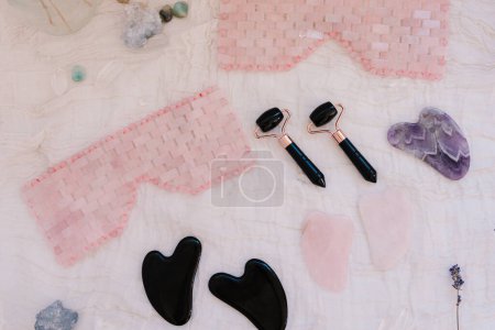 Foto de Máscara de cuarzo rosa y rodillo facial de obsidiana negra para el autocuidado - Imagen libre de derechos