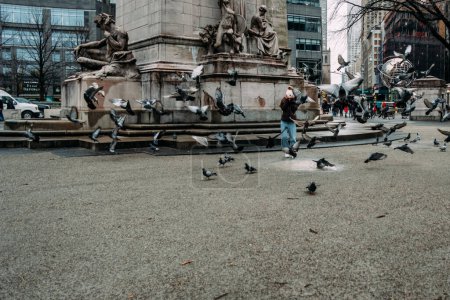 Téléchargez les photos : Adolescente courir à travers les pigeons dans le parc central - en image libre de droit