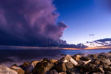 Photo for Rocky beach at sunset with storm clouds - Royalty Free Image