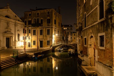 Téléchargez les photos : Vue sur le canal de Venise la nuit avec pont et bâtiments historiques. Italie. - en image libre de droit