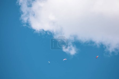 Foto de Los parapentes se elevan alto en el cielo en un día soleado en las montañas de la costa de BC. - Imagen libre de derechos