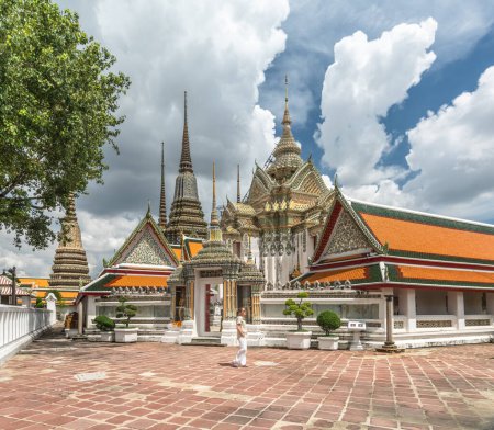 Téléchargez les photos : Touriste féminine caucasienne se promenant autour du temple bouddhiste Wat Pho - en image libre de droit