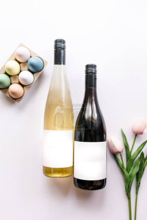 Photo for Carton of colorful fresh eggs, bottles of wine, pink tulips - Royalty Free Image