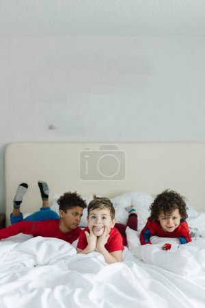 Photo for Interracial brothers being silly and goofy on hotel bed - Royalty Free Image