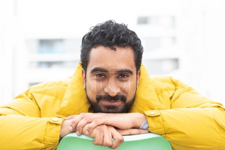 Téléchargez les photos : Jeune homme avec veste jaune et chaise verte - en image libre de droit