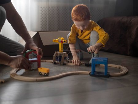 Foto de Papá y el bebé están construyendo una vía de madera para trenes. - Imagen libre de derechos