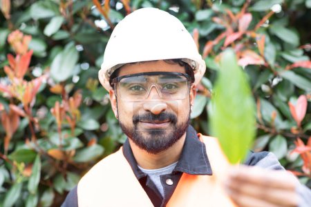 Téléchargez les photos : Jeune technicien lunettes de sécurité et casque tenant une feuille - en image libre de droit