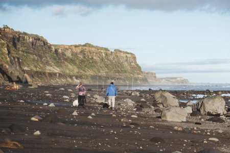 Téléchargez les photos : Père et fils marchant sur la plage portant une planche de surf avec un chien - en image libre de droit
