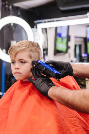 Foto de Niño blanco de 6 años cortándose el pelo en la peluquería de Portland - Imagen libre de derechos