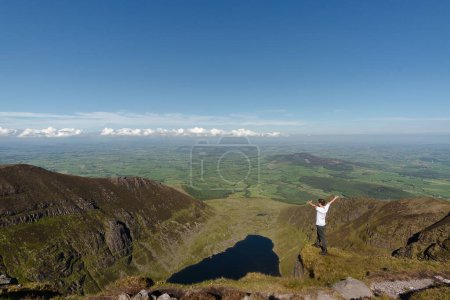 Foto de Hombre escalador de pie en la cima del lago Coumshingaun Irlanda - Imagen libre de derechos