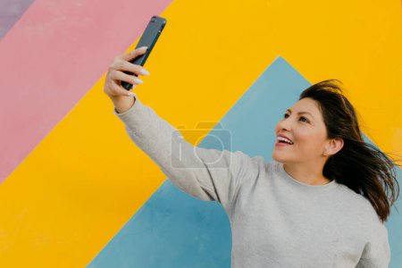 Foto de Linda mujer hispana haciendo una selfie y herrería - Imagen libre de derechos