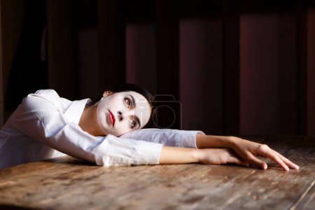Photo for Young actress in a costume with white make-up in the rehearsal theater - Royalty Free Image