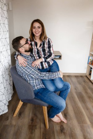 Téléchargez les photos : Jeune couple en vêtements à la maison étreinte pendant une pause déjeuner - en image libre de droit