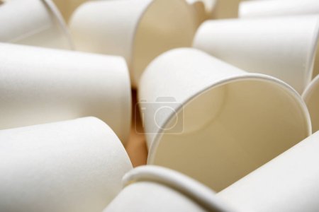 Foto de Vasos de cartón desechables dispersos en una mesa marrón - Imagen libre de derechos